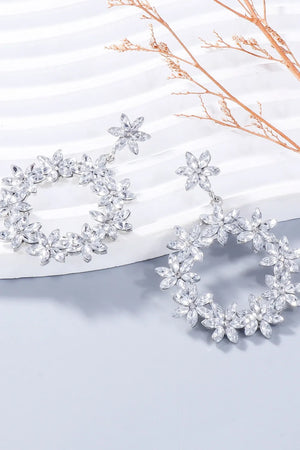 Silver floral halo drop earrings with crystal accents.
