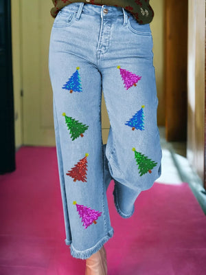 Light wash cropped wide-leg jeans with sequin Christmas tree appliques and frayed hem.