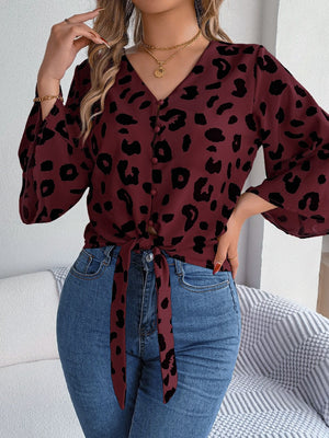 Burgundy leopard print tie-front blouse with button detail and bell sleeves.
