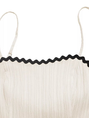 Cream cami dress with black scalloped contrast trim and textured fabric.