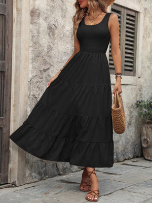 Black smocked bodice tiered maxi dress with scoop neck and sleeveless design.
