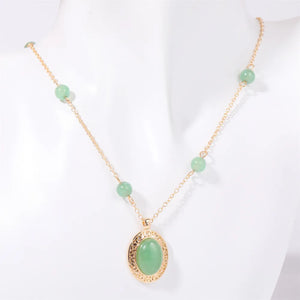 Gold chain necklace with neon green jade orb pendant and beaded accents
