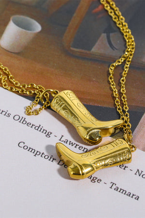 Gold cowboy boot charm necklace with intricate detailing on a delicate chain.