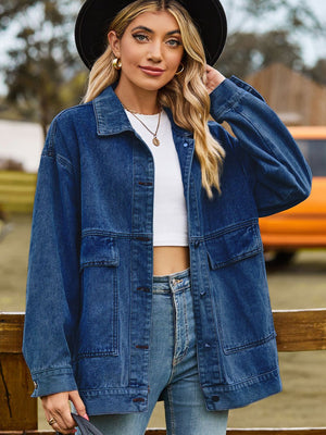 Oversized denim trucker jacket in medium blue wash with collared neck and chest pockets.