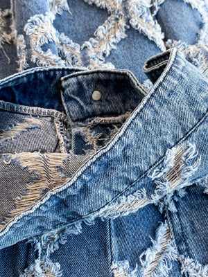 Distressed denim jacket and shorts set with frayed details and button closure.