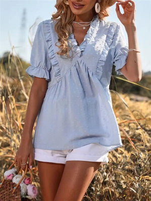 Light blue textured peplum blouse with ruffle trim and short sleeves.