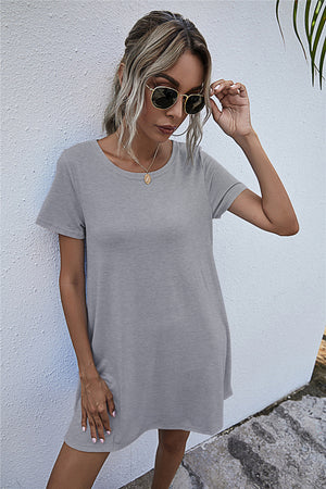 Light gray short sleeve relaxed tee dress with crew neck and side pockets.