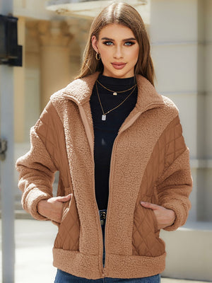 Camel quilted jacket with sherpa panels and zip front, featuring a stand-up collar.