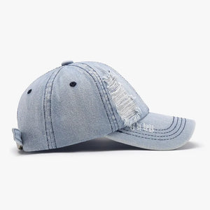 Light denim baseball cap with distressed shredded details and adjustable strap.