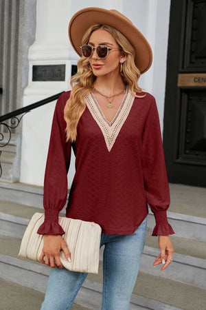 Burgundy textured V-neck blouse with lace trim and ruffled cuffs