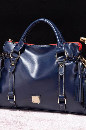 Dark blue structured satchel bag with gold hardware and tassel detail