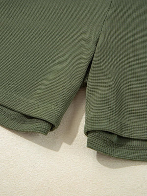 Moss green waffle knit romper detail showing hem and side slit