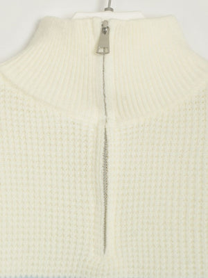 Cream ribbed knit sweater with half-zip neckline and textured waffle knit detail.