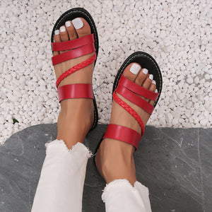Red braided strap open-toe flat sandals with multiple straps and ankle strap.