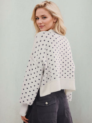 Dotted knit cropped crewneck sweater in white with dark blue pattern, crewneck, long sleeves, and ribbed hem.