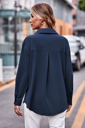 Dark blue oversized utility shirt with pleated back detail and button cuffs.