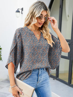 Floral print V-neck blouse with flutter sleeves and 100% polyester fabric.