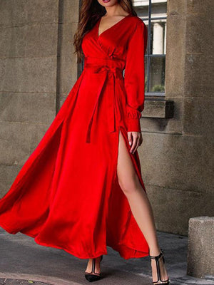 Red surplice maxi dress with long sleeves, defined waist tie, and high slit.
