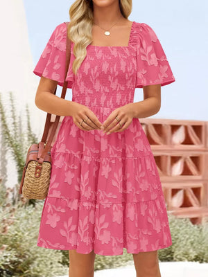 Strawberry smocked mini dress with tiered skirt, square neck, flutter sleeves, and floral embroidery.