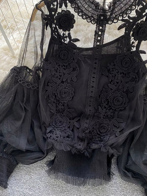 Black lace blouse with floral embroidery and sheer sleeves.