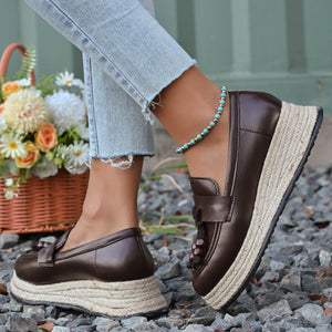 Brown espadrille wedge slip-on loafers with braided jute sole and tassel detail.