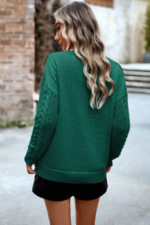Dark green acrylic sweater with cable-knit sleeves and relaxed fit.