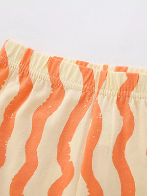 Toddler cotton shorts with orange wavy stripes and elastic waistband.