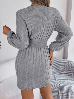 Cable knit mini dress in charcoal with a cinched waist and long sleeves.
