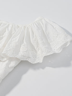 White eyelet tank top with ruffled trim and floral embroidery detail.