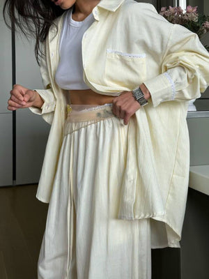 Pajama set in pastel yellow pinstripes with lace trim on shirt pocket and cuffs.
