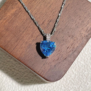 Dazzling heart pendant necklace in silver with a blue gemstone and delicate chain.