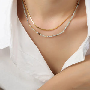 Gold layered necklace set with a flat snake chain and a beaded chain.