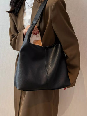 Black pebbled leather hobo shoulder bag with a single strap.