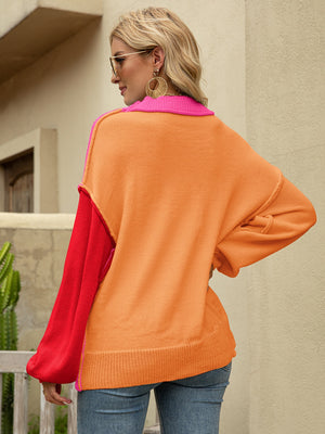 Colorblock drop shoulder knit sweater with orange body, red sleeves, and pink collar.