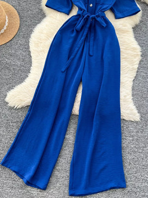 Blue belted wide-leg maternity jumpsuit with pockets and buttoned front.
