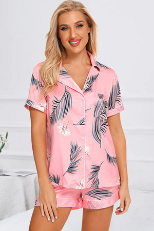Pink botanical print satin pajama set with button-front top and shorts.