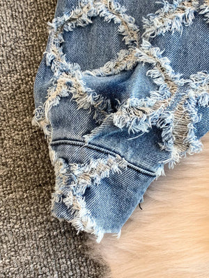 Distressed denim jacket and shorts set with frayed details and a light wash.