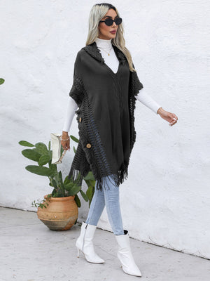 Dark gray textured knit poncho with fringe and wooden buttons, V-neck, open front.