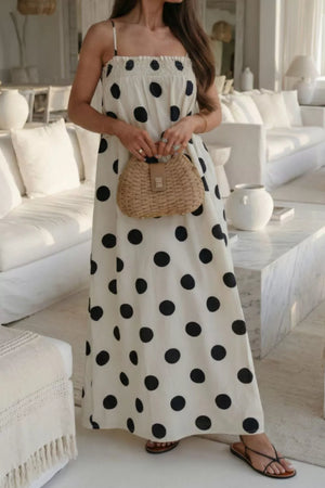 Cream polka dot maxi dress with smocked bodice and spaghetti straps.