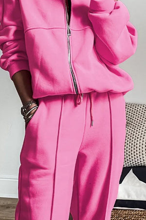Fuchsia pink seamed jogger set with zip-up jacket and drawstring waist.