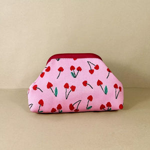 Pink knit clutch with red cherry pattern and maroon trim