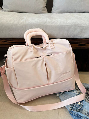 Pink travel organizer bag with adjustable strap and multiple pockets