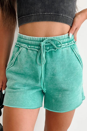 Mineral washed green cotton drawstring shorts with elastic waist and pockets.