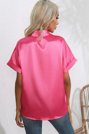 Hot pink satin blouse with cuffed short sleeves and a button-down front.