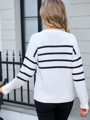 White and black striped knit pullover sweater with crew neck and long sleeves.