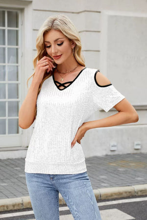 White sequin cold shoulder blouse with black criss-cross neckline detail.