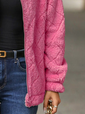Pink textured teddy zip-up jacket with diamond pattern, worn with jeans.
