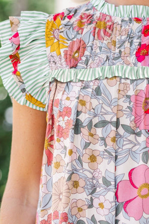 Floral blouse with ruffle sleeves and smocked neckline, featuring a vintage floral print and green stripe trim.