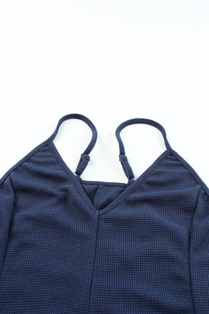 Navy relaxed-fit jersey jumpsuit with adjustable spaghetti straps and V-neck.