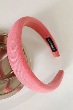 Padded headband in strawberry textured fabric with a black "Handmade" tag.